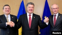 Presiden Ukraina Petro Poroshenko (tengah) berpose bersama Presiden Uni Eropa Jose Manuel Barroso (kiri) dan Presiden Dewan Eropa Herman Van Rompuy (kanan) di Brussels (27/6).