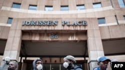 Informal vendors gather in front of a municipal office building in Braamfontein, South Africa, on April 8, 2020, as they try to obtain a permit for working during the national lockdown.