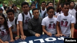 FILE - Myanmar journalists stand in front of a police vehicle transporting Reuters journalists Wa Lone and Kyaw Soe Oo to Insein prison after the court verdict in Yangon, Myanmar, Sept. 3, 2018. 