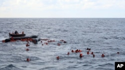 Refugees and migrants are rescued by members of the Spanish NGO Proactiva Open Arms, after leaving Libya trying to reach European soil aboard an overcrowded rubber boat in the Mediterranean sea, Nov. 11, 2020.