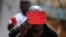 FILE - A Congolese opposition party supporter displays a red card against President Joseph Kabila in Kinshasa, Democratic Republic of the Congo, Dec. 19, 2016.