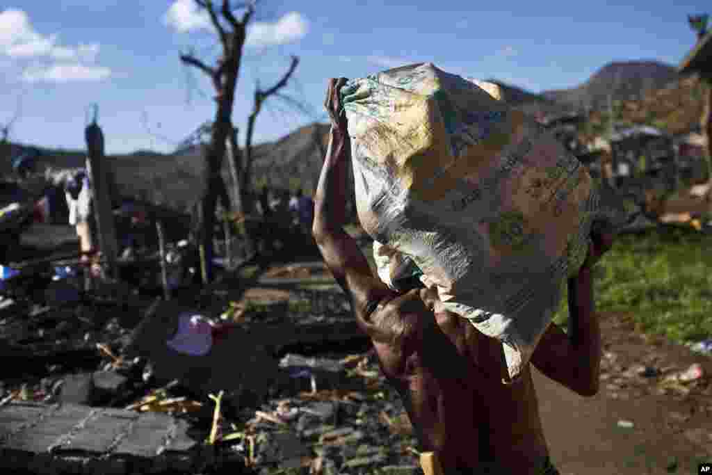 A Typhoon Haiyan survivor carries a bag of his recovered belongings in the ruins of his rural neighborhood on the outskirts of Tacloban, Philippines, Nov. 18, 2013.