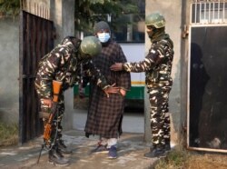 FILE - Indian soldiers frisk a voter as he arrives to cast his vote during the first phase of District Development Councils election on the outskirts of Srinagar, Indian controlled Kashmir, Nov. 28, 2020.