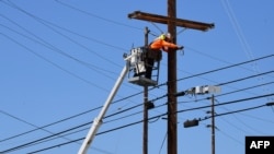 FILE - A man works on power lines in Los Angeles, California, May 4, 2020.