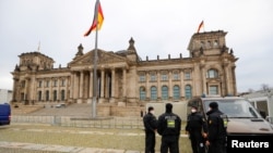 FILE -Police officers stand outside the Reichstag building, seat of Germany's lower house of parliament in Berlin, Nov. 18, 2020.