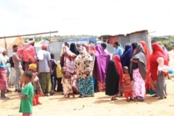Refugees gather in front of a makeshift tent to collect aid at the Yemeni Refugees Camp near Somali capital Mogadishu. (Courtesy of Muslim Aid)
