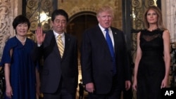 President Donald Trump, second from right, and first lady Melania Trump, right, stop to pose for a photo with Japanese Prime Minister Shinzo Abe, second from left, and his wife Akie Abe, left, before they have dinner at Mar-a-Lago in Palm Beach, Fla., Feb