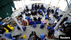 Migrants are seen on board the MV Aquarius, in the Mediterranean Sea, between Malta and Linosa, Aug. 14, 2018. 