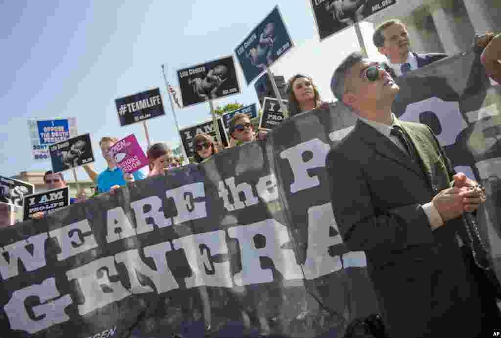 Michael Hichborn kneels and prays as he joins demonstrators while waiting for the Supreme Court decision on the Hobby Lobby case outside the Supreme Court, in Washington, June 30, 2014.