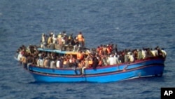 FILE - In this photo released by the Italian Navy June 29, 2014, a boat overcrowded with migrants is pictured in the Mediterranean Sea.
