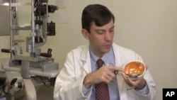 Dr. Jason Comander, inherited retinal disorder specialist at Massachusetts Eye and Ear Infirmary in Boston points to a model of an eye during an interview on Jan. 8, 2020. Comander's hospital plans to enroll patients in a gene editing treatment for blindn