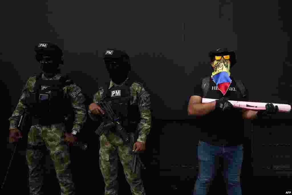 Un manifestante junto a los soldados durante una protesta contra el gobierno del presidente colombiano Iván Duque, en Cali.