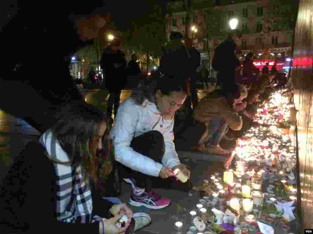 People pay homage to terror attack victims at the Place de la Republique square in Paris, France after panic spread about another possible attack, Nov. 15, 2015. (Photo: D. Schearf / VOA)