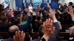 Reporters raise their hands to ask a question in the White House press room, Feb. 20, 2025, in Washington. The AP filed suit against White House officials after being barred from some of President Donald Trump's events. 