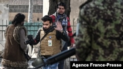 FILE - Taliban fighters walk toward journalists during a protest in Kabul, Afghanistan, Dec. 28, 2021.