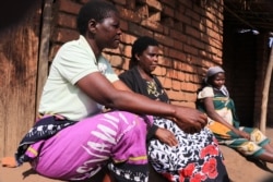 Women connected with Mothers' Group, an organization for women, talk together in Phalombe district, Malawi. (Lameck Masina/VOA)