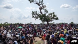 Thousands of people wait in the hot sun near the air drop zone in Leer, South Sudan, July 5, 2014.
