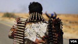 Un combatiente de la oposición cargando municiones mientras avanzan hacia la oriental ciudad de Sirte.