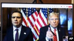 নব-নির্বাচিত প্রেসিডেন্ট ডনাল্ড ট্রাম্প(ডানে) তাঁর অ্যাটর্নি টড ব্লাঞ্চের সঙ্গে এই মামলার রায় শোনার জন্য ভার্চুয়ালি হাজির হন। নিউ ইয়র্কের ফোজদারি আদালতে তথ্য গোপন করতে অর্থ প্রদানের অভিযোগে তাঁকে দোষী সাব্যস্ত করা হয়। নিউ ইয়র্ক ১০ জানুয়ারি,২০২৫। 