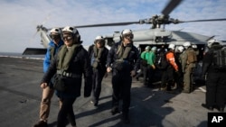 La canciller argentina, Diana Mondino, al frente, el ministro de Defensa, Luis Petri, y el embajador de EEUU en Argentina, Marc R. Stanley, llegan al portaviones USS George Washington frente a las costas de Argentina, durante ejercicios conjuntos, el 30 de mayo de 2024.