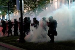 Police clear a park during clashes with protesters outside the Kenosha County Courthouse late, Aug. 25, 2020, in Kenosha, Wis., during demonstrations over the Sunday shooting of Jacob Blake.