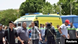 Police and people stand near the scene of a foiled suicide attack in Luxor, Egypt, June 10, 2015. A suicide bomber blew himself up in the parking lot of Karnak temple on Wednesday, security sources and witnesses said.