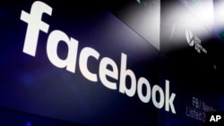 FILE- The logo for Facebook appears on screens at the Nasdaq MarketSite in New York's Times Square, March 29, 2018.