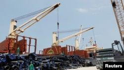 Des travailleurs déchargent des tuyaux sur un chantier de construction d'une raffinerie de pétrole de Dangote dans le district d'Ibeju Lekki, à la périphérie de Lagos, au Nigéria, le 7 août 2019. (REUTERS / Temilade Adelaja)