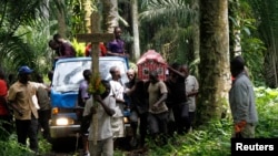 De proches d'une victime d'une attaque attribuée aux ADF accompagne la dépouille mortelle au cimetière, à Mbau, près de Beni, Nord-Kivu,21 octobre 2014.