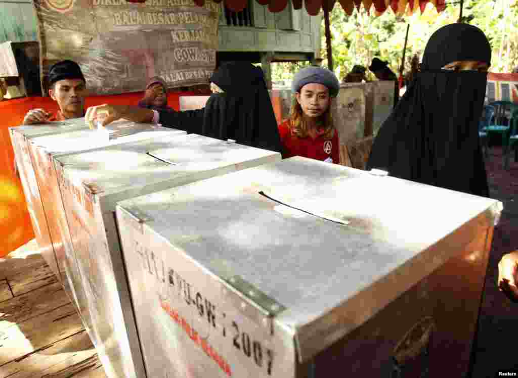 Members of the Muslim group An-Nadzir cast their ballots during voting in parliamentary elections at a polling station in Gowa, South Sulawesi, Indonesia, April 9, 2014.
