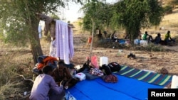 Ethiopians who fled war in Tigray region, rest under trees with their belongings at the Um-Rakoba camp on the Sudan-Ethiopia border in Al-Qadarif state, Sudan Nov. 19, 2020.