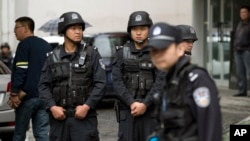 FILE - Armed policemen stand guard in China's Xinjiang region, May 22, 2014. 