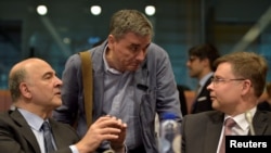 Ủy viên hội đồng Kinh tế và Tài chính Châu Âu Pierre Moscovici (trái) nói chuyện với Bộ trưởng Tài chính Hy Lạp Euclid Tsakalotos (giữa) và Phó chủ tịch Ủy ban châu Âu Valdis Dombrovskis trong cuộc họp các bộ trưởng tài chính khu vực châu Âu, ngày 24 tháng 5 năm 2016.