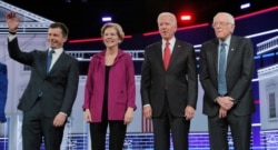Democratic U.S. presidential candidates South Bend Mayor Pete Buttigieg, Senator Elizabeth Warren, former Vice President Joe Biden, and Senator Bernie Sanders pose at the start of their fifth 2020 campaign debate in Atlanta, Nov. 20, 2019.