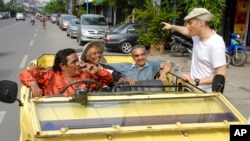 "The Act of Killing" director Joshua Oppenheimer (right) speaks with his main character, Anwar Congo (seated, wearing cap). (AP/Drafthouse Films)
