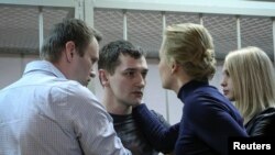 Alexei Navalny, aktivis politik dan blogger anti korupsi, beserta istrinya Yulia, terlihat bersama Oleg Navalny dan istrinya Victoria sesudah sidang pengadilan di Moskow, 30/12/2014. 