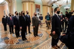 FILE - Democratic House impeachment managers stand before entering the Senate Chamber as they deliver to the Senate the article of impeachment alleging incitement of insurrection against former President Donald Trump, in Washington, Jan. 25, 2021.
