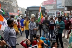 Supporters of India's main opposition Congress party shout slogans and block a road as part of a protest during a nationwide strike against the newly passed farm bills, in Kolkata, India, Dec. 8, 2020.