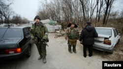 Pro-Russian separatists inspect cars at checkpoint in the Spartak area near the Sergey Prokofiev International Airport in Donetsk, Nov. 18, 2014. 