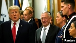 Secretary of Defense James Mattis, right, escorts U.S. President Donald Trump as he greets military personnel after attending a meeting at the Pentagon in Arlington, Virginia, July 20, 2017. 