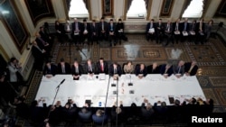 FILE - U.S. Trade Representative Robert Lighthizer, Treasury Secretary Steven Mnuchin, and other U.S. officials, with China's Vice Premier Liu He and other Chinese officials before the start of U.S.-China trade talks in Washington, Feb. 21, 2019. 