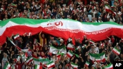 Iranian women cheer during a soccer match between their national team and Cambodia in the 2022 World Cup qualifier, Oct. 10, 2019.