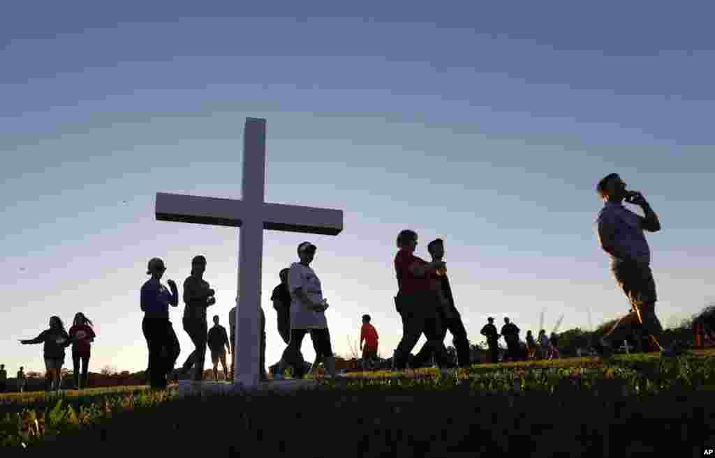 Attendees pass a wooden cross as they arrive at a candlelight vigil for the victims of the shooting at Marjory Stoneman Douglas High School in Parkland, Florida, Feb. 15, 2018. 