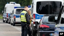 German police officers check the documents of a driver of a car with French license plates near the border with Belgium, in Aachen, Germany, Sept. 16, 2024, as Germany begins expanding checks at all of its land borders.