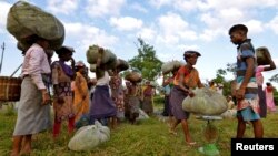 FILE - Tea garden workers gather to weigh tea leaves after plucking them at a tea estate in Nagaon district, in the northeastern state of Assam, India, Nov. 2, 2016. 