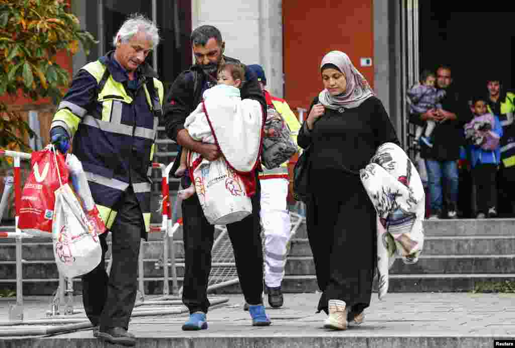 Migrants walk after arriving by train to the main railway station in Munich, Germany, Sept. 6, 2015.