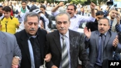 Người biểu tình ném trứng về phía ông Abdul-Aziz al-Khair (giữa) và các nhà lãnh đạo đối lập khác trong khi các nhân vật này tìm cách vào trụ sở Liên doàn Ả Rập để dự một cuộc họp về bạo động ở Syria