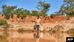 រូបឯកសារ៖ បុរស​ម្នាក់​ដង​ទឹក​ពី​អូរ​មួយ នៅ​ភូមិ Matobo ក្នុង​តំបន់ Matabeleland នៃ​ទី្វប​អាហ្រ្វិក កាលពីថ្ងៃទី១០ ខែឧសភា ឆ្នាំ២០២៤។