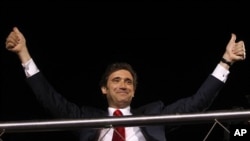 Pedro Passos Coelho, leader of the center-right Social Democratic Party, PSD, gestures to supporters from the top of an open deck bus in Lisbon after his party won Portugal's general elections, June 5 2011