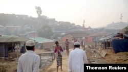 Rohingya refugees walk on a road at the Balukhali camp in Cox's Bazar on May 14, 2020.